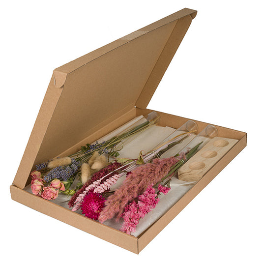 Geschenkbox mit drei Sträußen Trockenblumen in pink, drei Vasen und einem Holzhalter für die Glasvasen